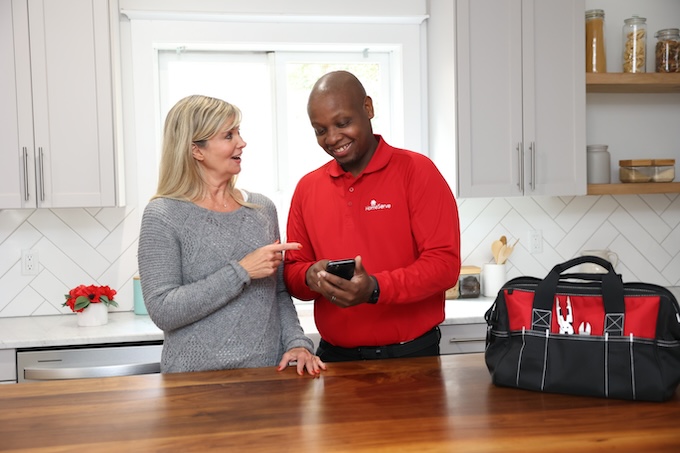 Homeserve technician showing a woman something on his phone